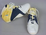 pair of yellow and blue sneakers with white laces on a gray surface