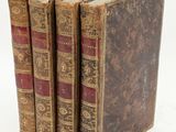 three old books sitting on top of each other on a white surface
