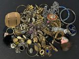 a pile of assorted jewelry on a black surface