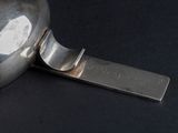 a silver spoon with a metal handle on a black surface