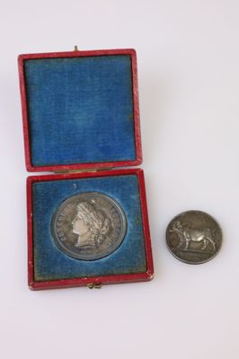une pièce d'argent dans une boîte rouge, à côté d'une pièce d'argent