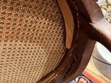 a wooden chair with a woven seat on a rug