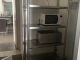 un micro-ondes et un four à micro-ondes posés sur une étagère dans une pièce