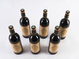 six bottles of wine are arranged in a circle on a white surface
