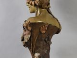 bronze bust of a woman with a sunflower in her hair