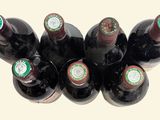 bottles of wine are lined up in a row on a white surface