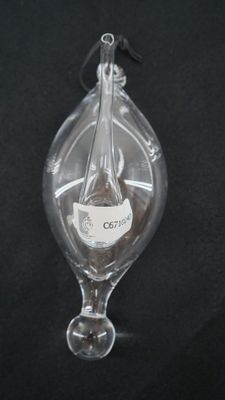 une bouteille en verre contenant une bouteille de vin, posée sur une surface noire