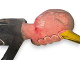 a wooden duck head with a yellow beak on a white background
