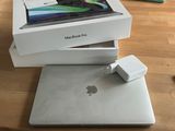 a box with a charger on top of a macbook pro