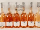 six bottles of rose wine lined up in a row in front of a box