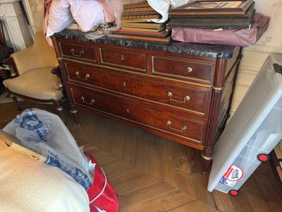 une commode sur laquelle sont posés plein de vêtements