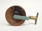 an old wooden spinning machine with a green handle on a white surface