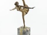 bronze statue of a woman in a dress on a marble block