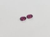 a pair of pink tourmaline gems on a white surface