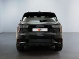 the rear end of a black car in a white room