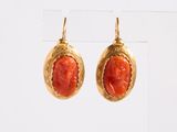 une photo d'une paire de boucles d'oreilles en or et en corail