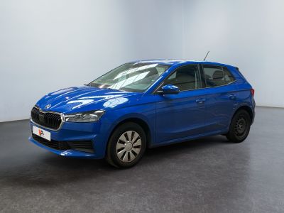 a blue car parked in a room with a white wall