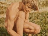 a man kneeling in the grass with a frisbee in his hand