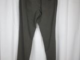 a pair of olive green pants hanging on a hanger in front of a white curtain