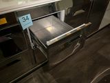 a silver oven with a metal drawer in the middle of it