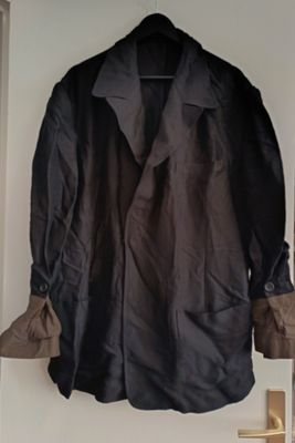 coat hanging on a wall in a room with a door open