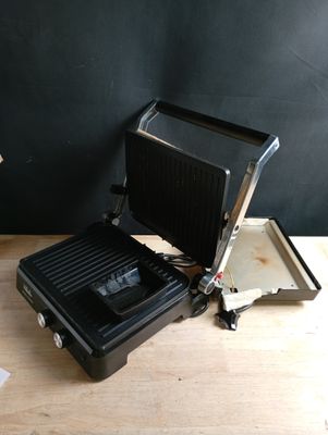 une grille noire et argentée posée sur une table en bois