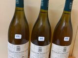 three bottles of wine sitting on top of a wooden box
