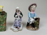 three figurines of children sitting on a bench