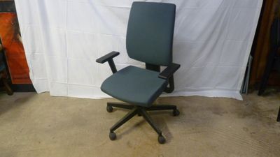 a blue office chair sitting in front of a white backdrop
