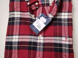 a close up of a red plaid shirt with a tag on it