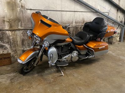 an orange motorcycle parked in a garage with a black seat