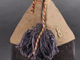 a brown hat with a tassel on top of a mannequin head