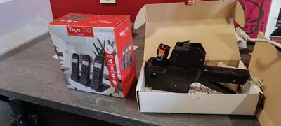 une boîte de téléphones portables posée sur un comptoir à côté d'une boîte de télécommandes