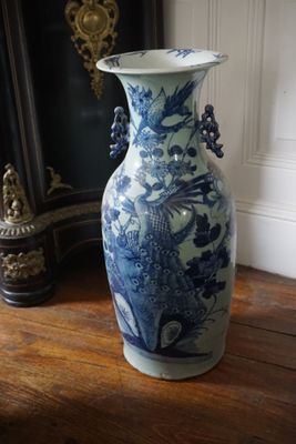 un grand vase bleu et blanc posé sur une table en bois