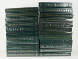 plusieurs livres empilés sur une surface blanche
