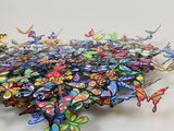 a large group of colorful butterflies on a white surface