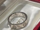 une bague en argent dans un coffret rouge sur lequel est gravé un nom