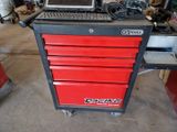 a red tool cabinet with a laptop on top of it