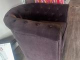 a chair that is sitting in a room with clothes on a hanger