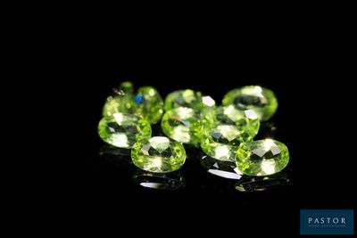 a close up of a bunch of green gems on a black surface