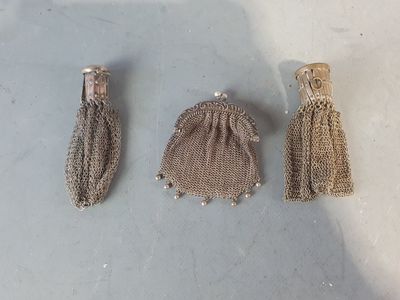 trois petits sacs ornés de pompons, posés les uns à côté des autres sur une table