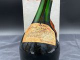 an old bottle of wine sitting on top of a table next to a box
