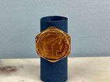 an image of a gold coin ring on a blue cylinder