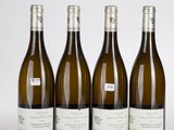 trois bouteilles de vin sont alignées sur une surface blanche