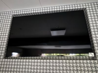 a flat screen tv mounted on the wall above a sink