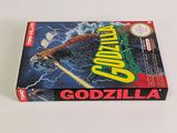 the box of godzilla is sitting on a white surface
