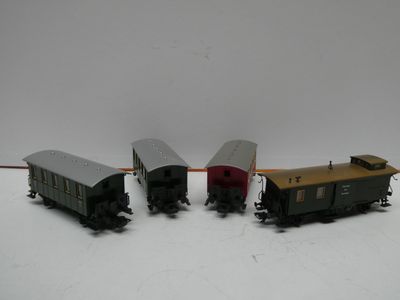 trois petits trains miniatures posés sur une surface blanche, avec un fond blanc