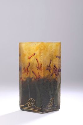 un vase en verre avec un tableau posé sur une table