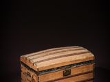 an old wooden box with a striped lid on a dark background