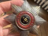 someone is holding a silver and red badge with a gold star on it